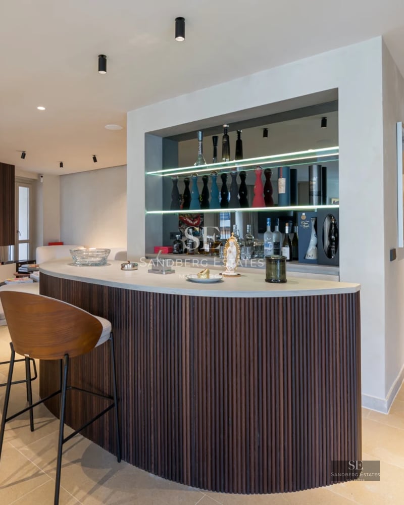 Spacious living room with panoramic windows, light wood floors, modern fireplace, and minimalist design furniture. Natural lighting.