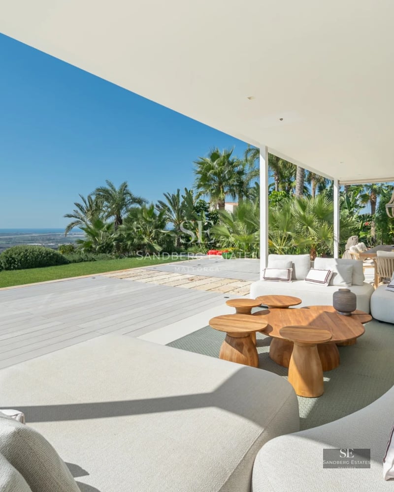 Spacious balcony with panoramic sea views. Modern furniture, glass railing, wood flooring. Ambient lighting. Luxury and comfort.