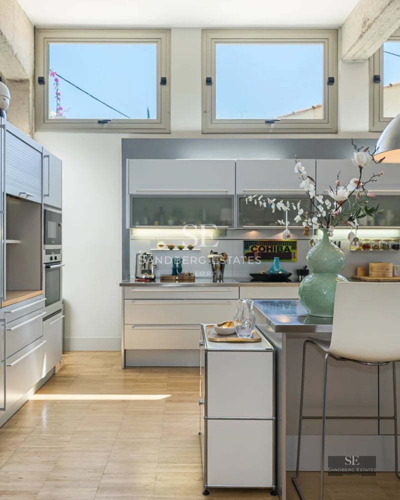 View of an infinity pool surrounded by a lush garden. Modern architecture with large windows maximizing natural light.