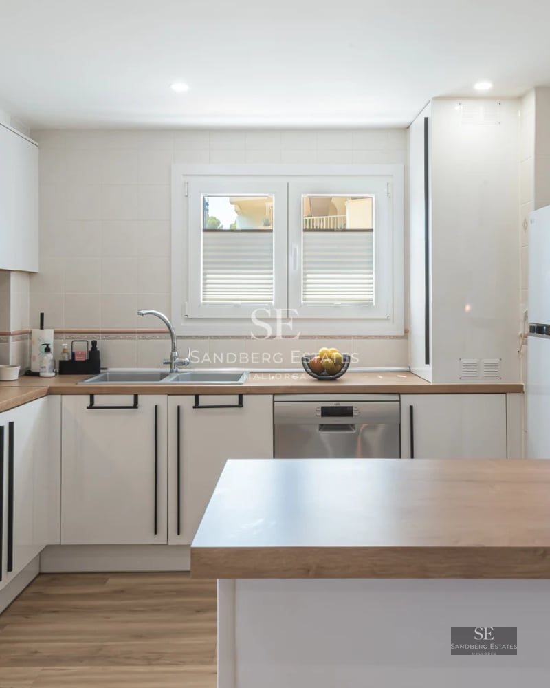 Spacious, bright living room with large windows, modern furniture, wooden floors, and garden views. Contemporary architecture.