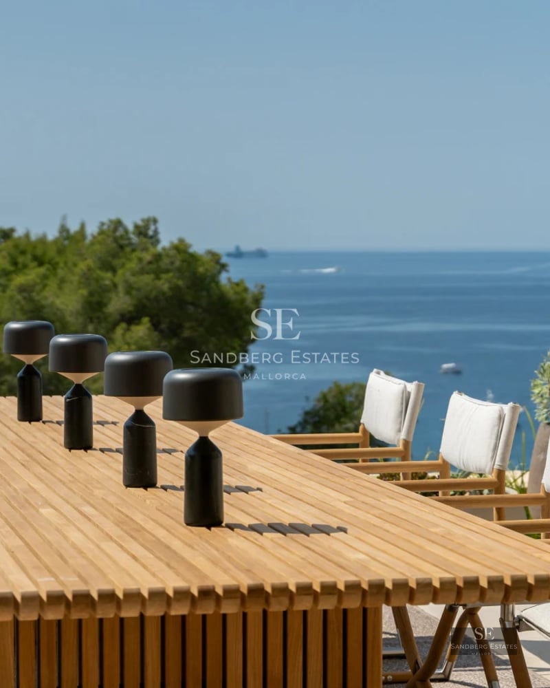 Spacious balcony overlooking the sea. Modern design, glass railing, elegant furniture. Ideal for relaxing and enjoying the scenery.