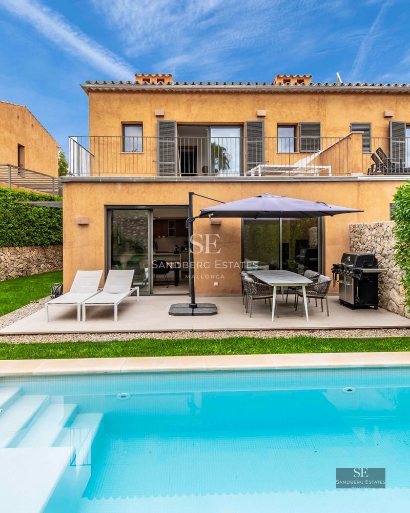 View of a modern villa with infinity pool, lounge chairs, lush garden, and panoramic views. Minimalist architecture and luxury finishes.