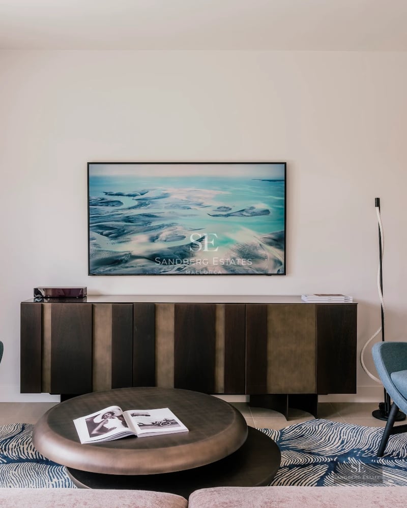 Spacious living room with large windows, panoramic sea views, modern furniture, and light wood floors.