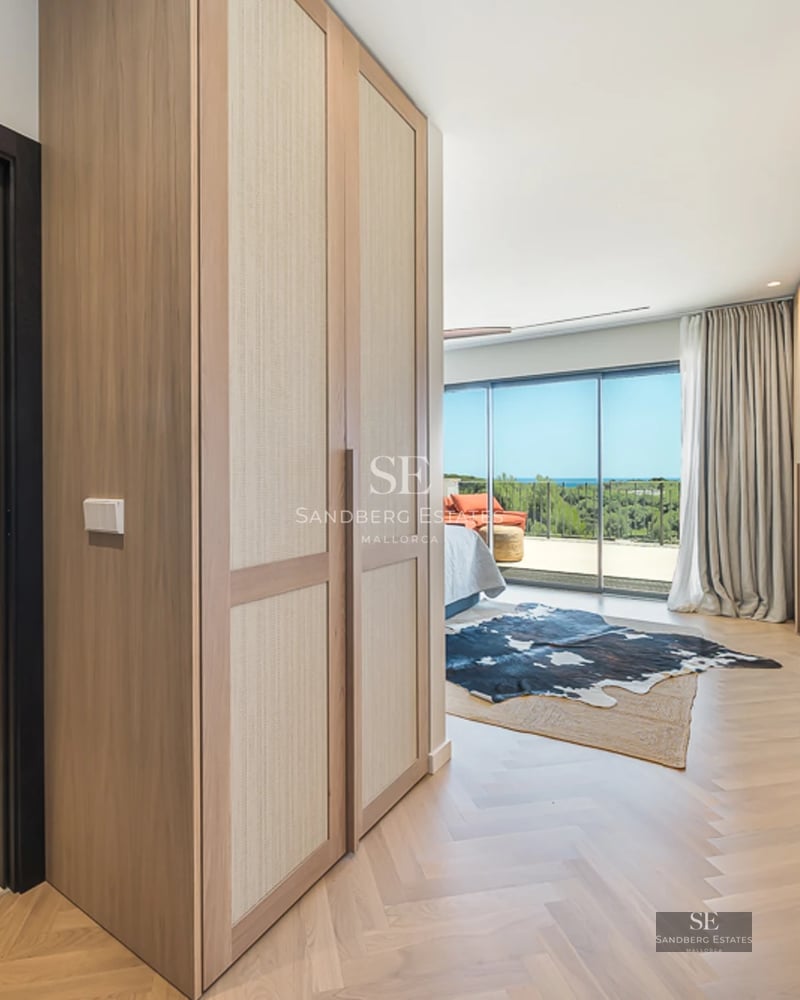 Vaste salon avec grandes baies vitrées, parquet clair, cheminée moderne et mobilier design minimaliste. Lumière naturelle abondante.