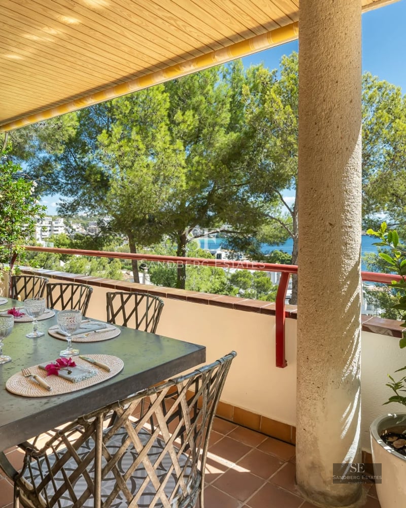 Bright living room with balcony and sea view. Modern decor, light wood floors and large windows.
