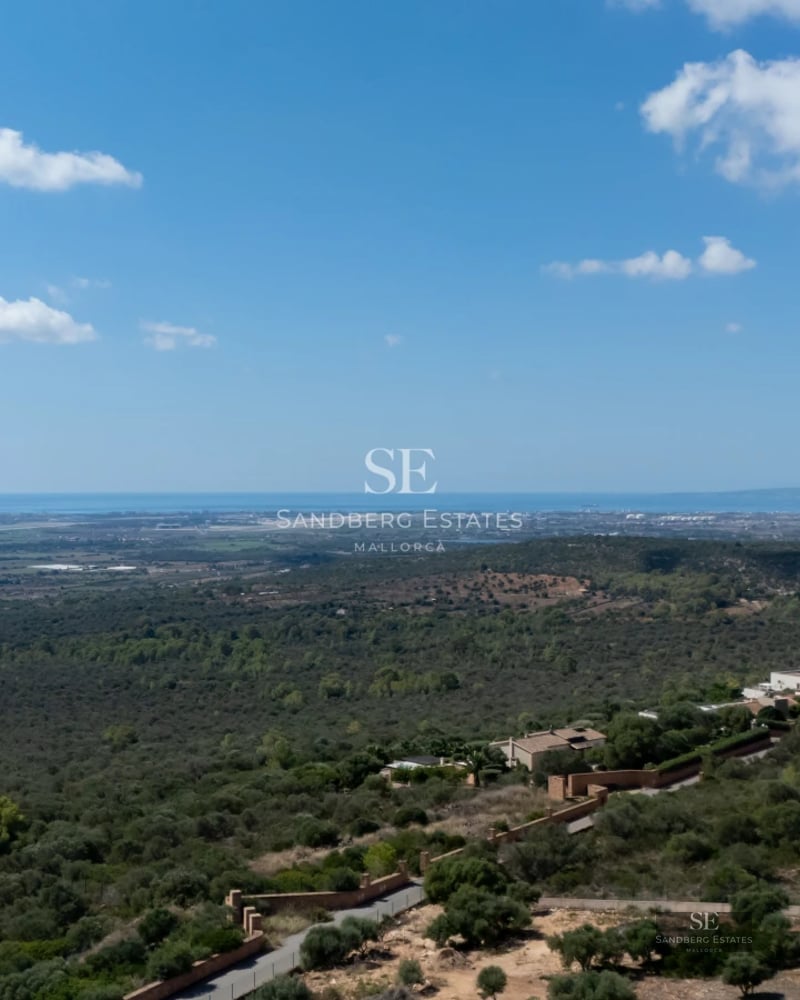 Spacious balcony with panoramic sea views. Modern design featuring glass railings and outdoor furniture. Ambient lighting.