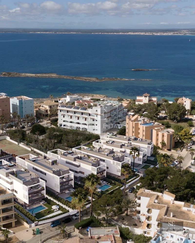 Spacious terrace with panoramic sea view. Modern furniture, glass railing, and tiled floor. Ambient lighting.