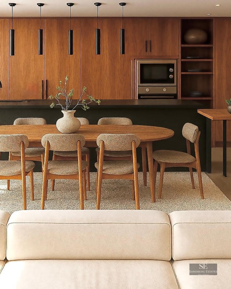 Elegant dining area with a wooden oval table and upholstered chairs set against a modern kitchen with wood cabinetry.