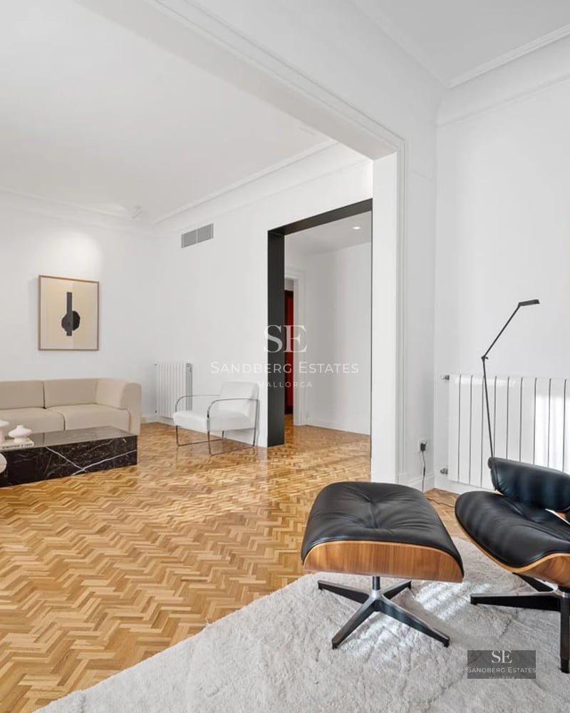 View of a luxury villa with infinity pool, surrounded by greenery. Modern architecture with large windows and high-quality finishes.