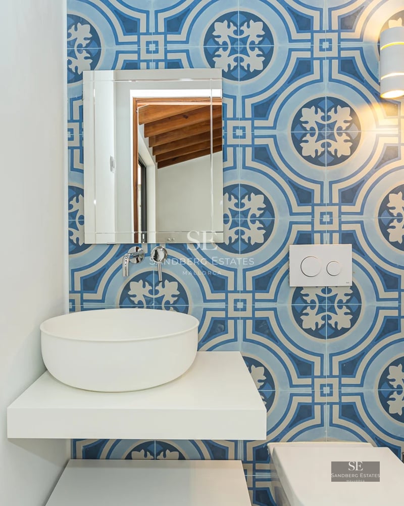 Bright, spacious living room boasting sea views through large windows. Beige sofa, light rug, and minimalist decor.