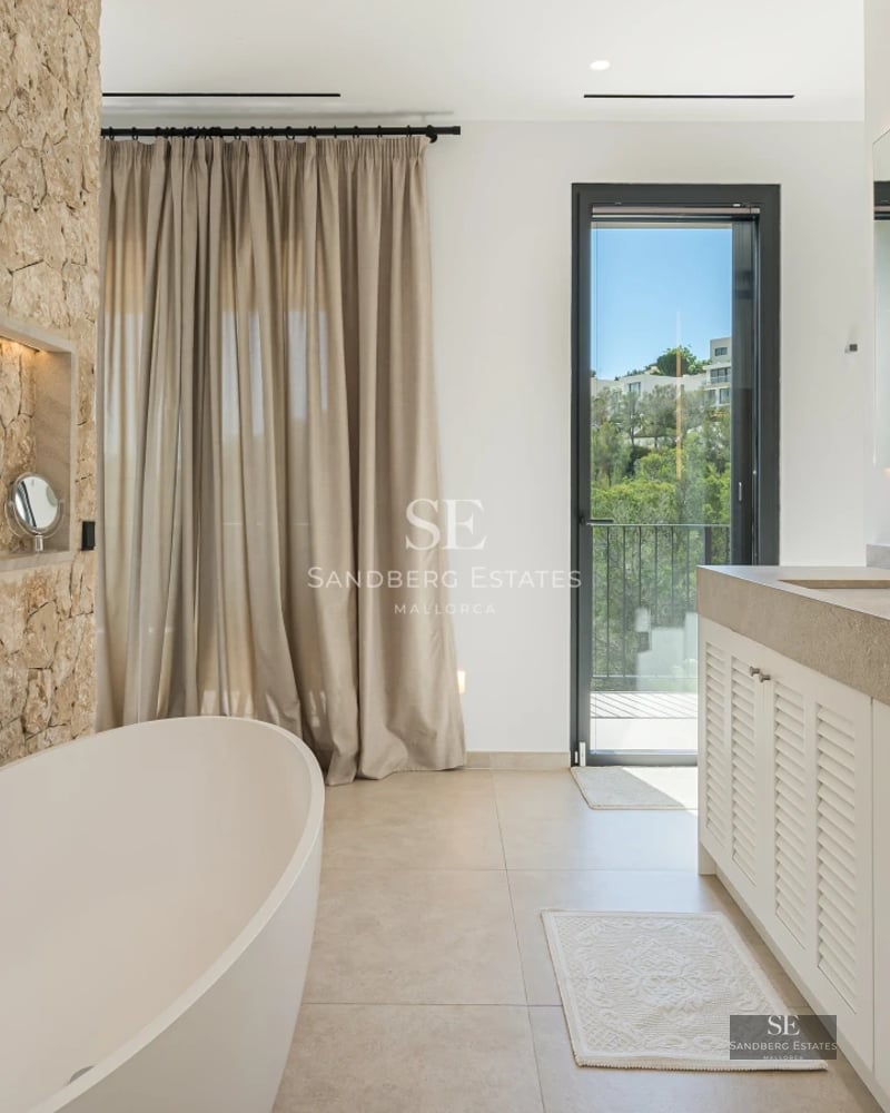 Exterior view of a modern villa with a pool, lush garden, and large windows maximizing natural light and views.