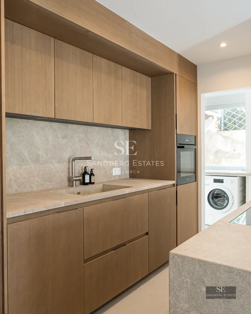 Bright living room with outdoor pool, large windows, minimalist decor, light wood floors, and contemporary designer furniture.
