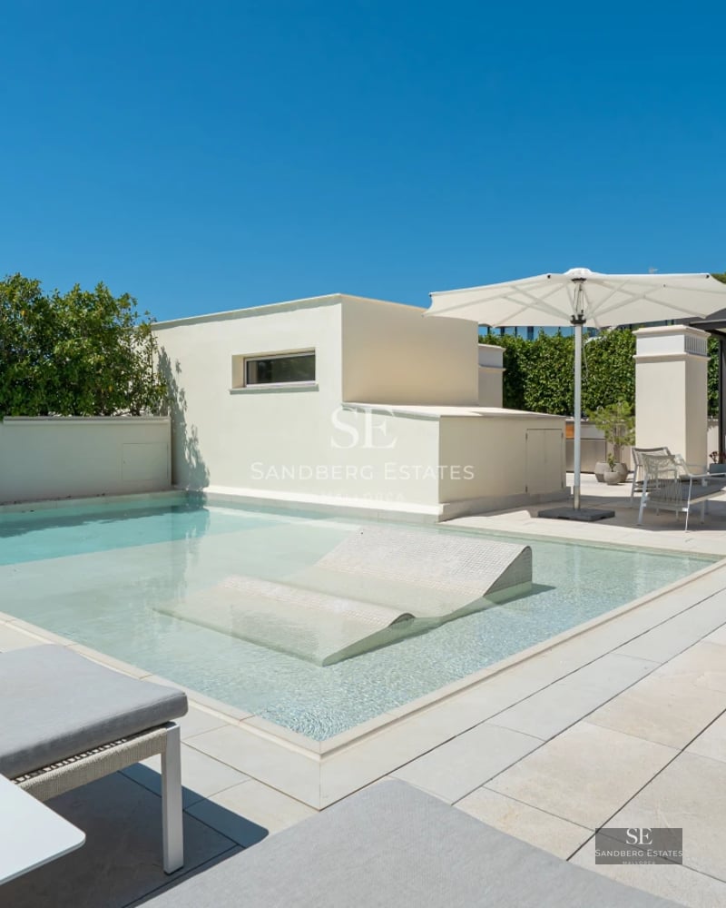 Spacious terrace with pool, sea views, modern furniture, and lush greenery. Elegant architectural design.