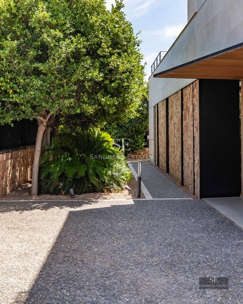 Spacious exterior with turquoise pool, modern sun loungers, and lush greenery. Minimalist and elegant design.