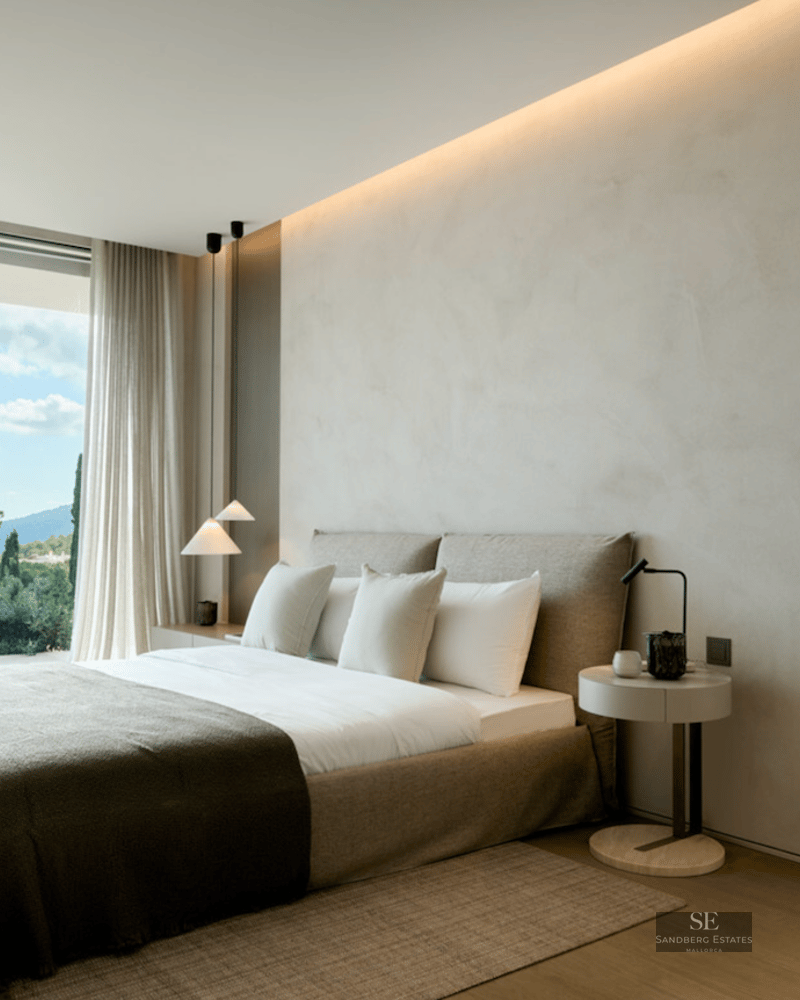 Minimalist master bedroom featuring floor-to-ceiling windows with mountain views and an open ensuite bathroom.