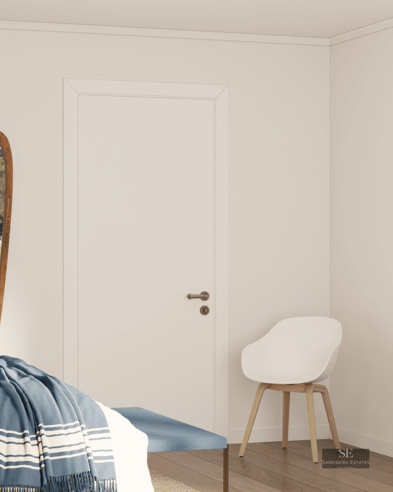 Chambre minimaliste avec miroir en bois, murs blancs, meubles en chêne et couvre-lit bleu.