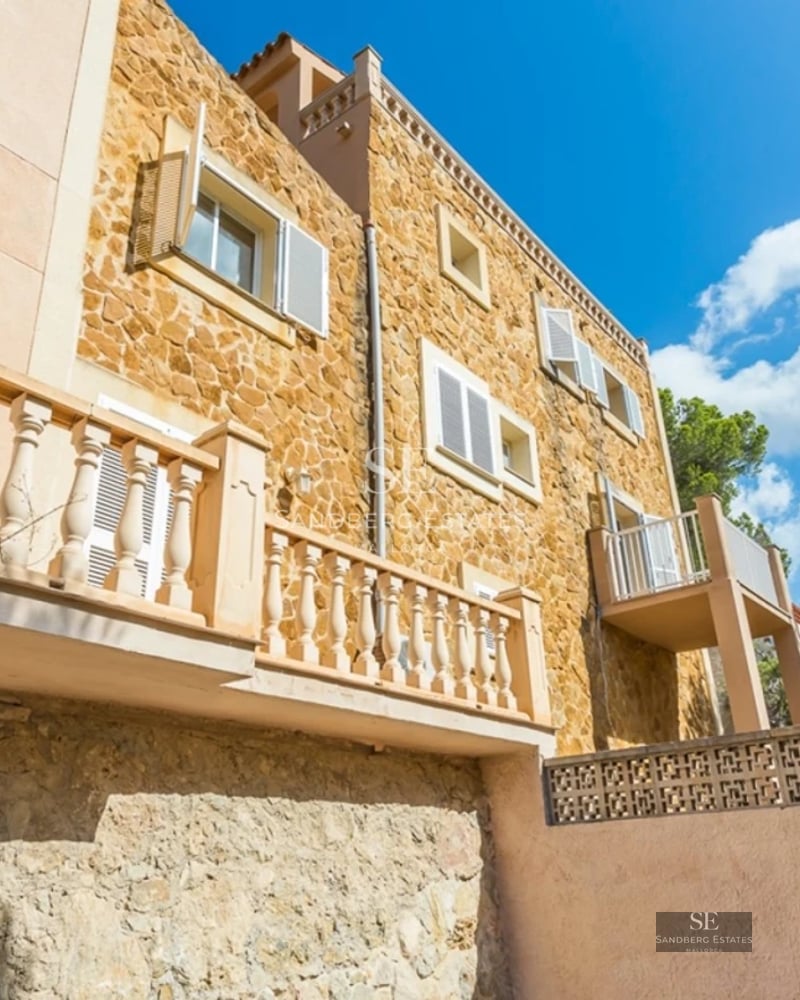 Spacious living room with floor-to-ceiling windows overlooking the sea. Modern design, natural light, neutral color palette. Wood floors and elegant furniture.
