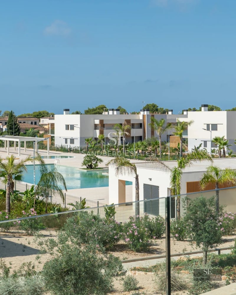 Spacious living room with floor-to-ceiling windows, modern furniture, and access to terrace with pool. Natural light and minimalist design.