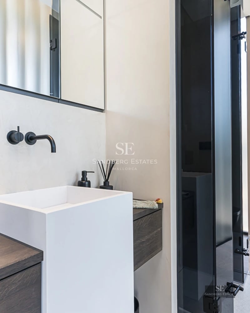 Exterior view of a modern villa with a pool, garden, and large windows. Minimalist architectural design and well-maintained landscaping.