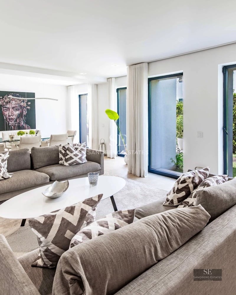 View of modern villa with infinity pool, expansive terraces and lush garden. Minimalist architectural design with natural light.