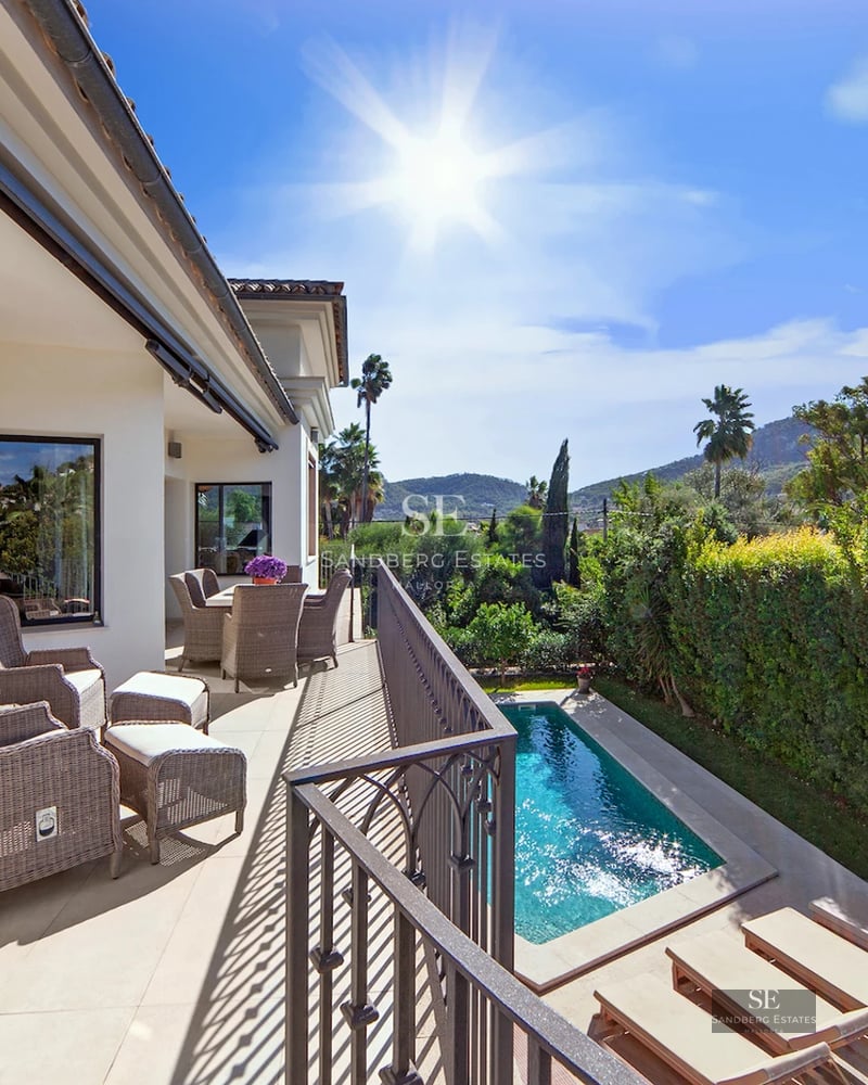 Spacious terrace with pool, sun loungers, lush greenery and unobstructed views. Modern and elegant design.