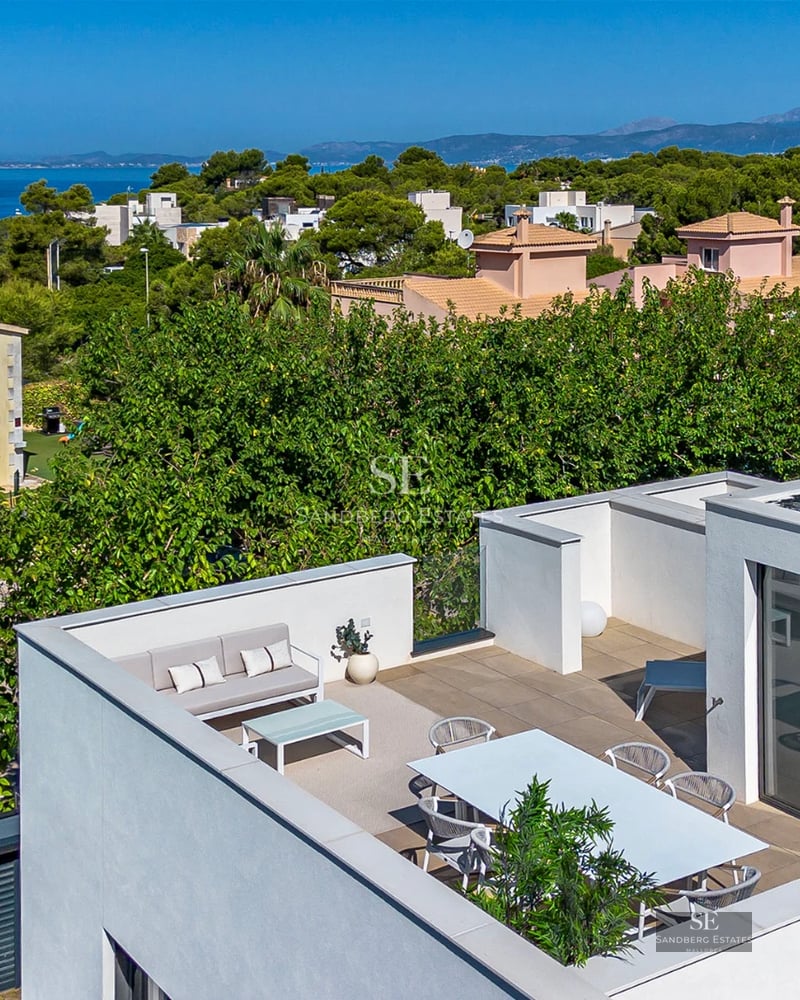 Exterior view of a modern villa with infinity pool, lush garden, and spacious terraces. Minimalist design with large windows.