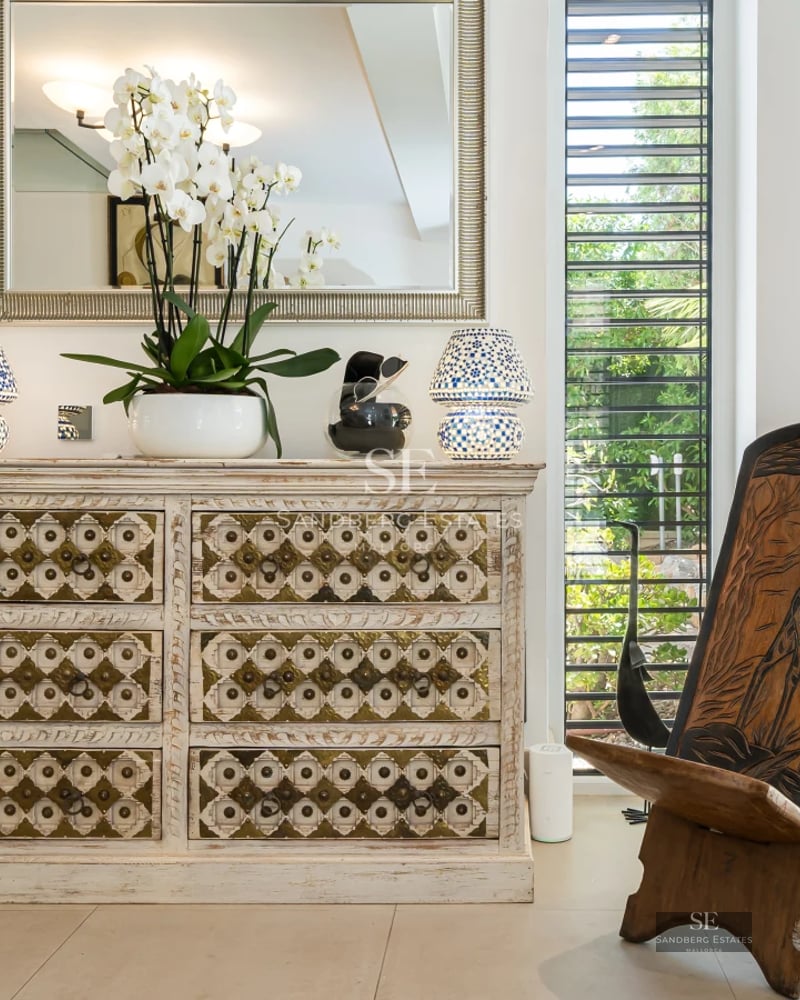 View of a luxurious villa with a pool, garden, and modern architecture. Large windows and elegant design.