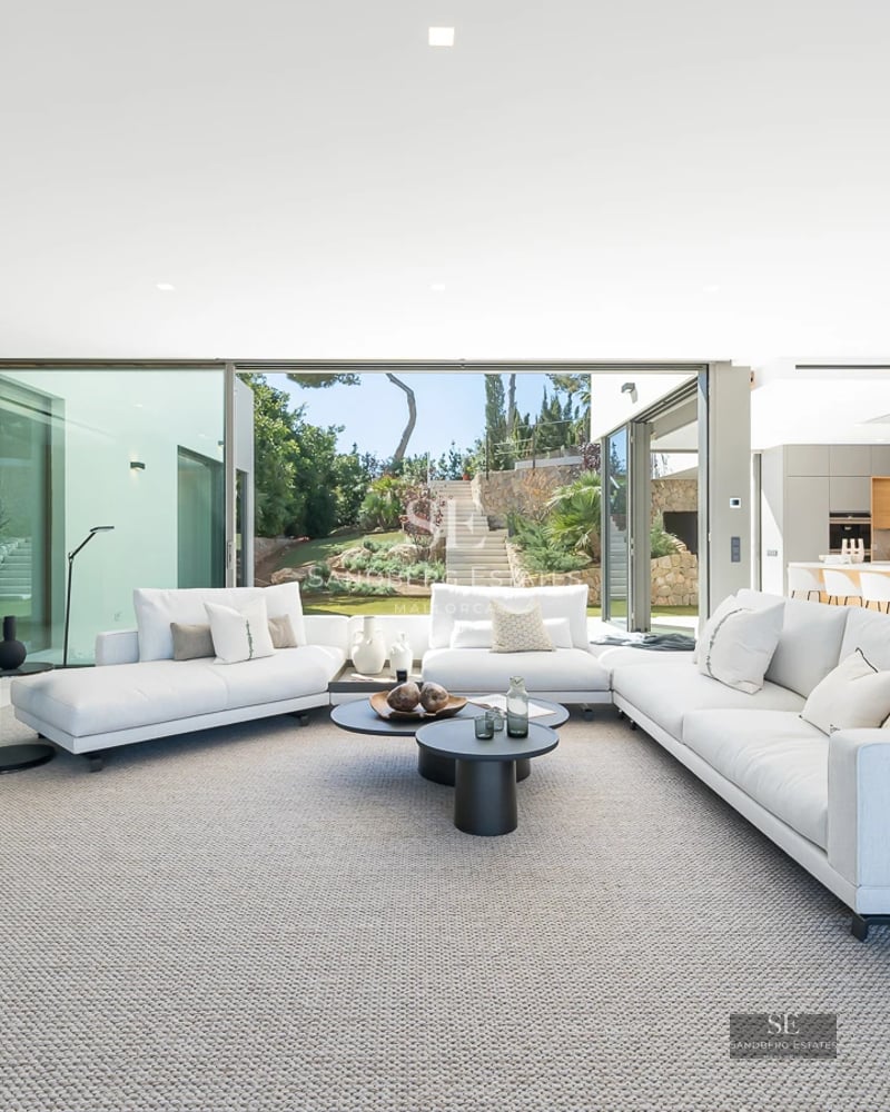 Aerial view of a modern villa with infinity pool, surrounded by gardens and spacious terraces. Minimalist and elegant architecture.