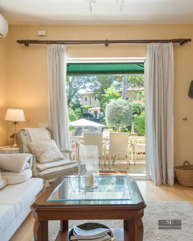 Exterior view of a modern villa featuring an infinity pool, expansive terraces, and lush gardens. Minimalist architecture with large windows.