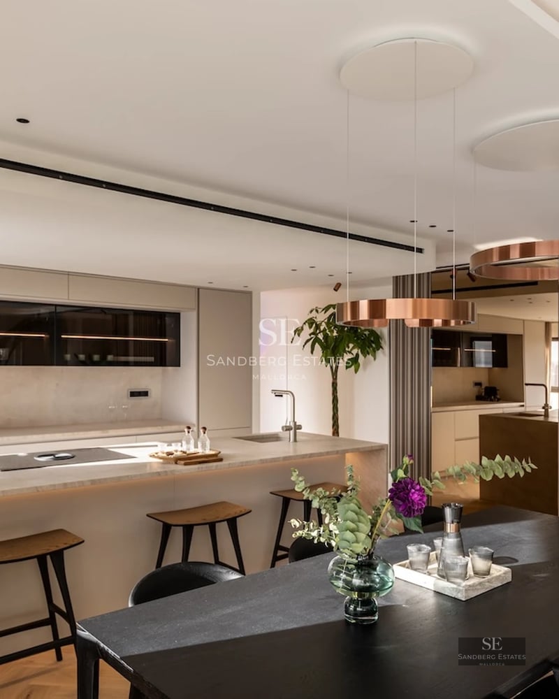 View of the infinity pool from the terrace. Modern design with sun loungers, umbrellas, and lush greenery. Elegance and comfort.