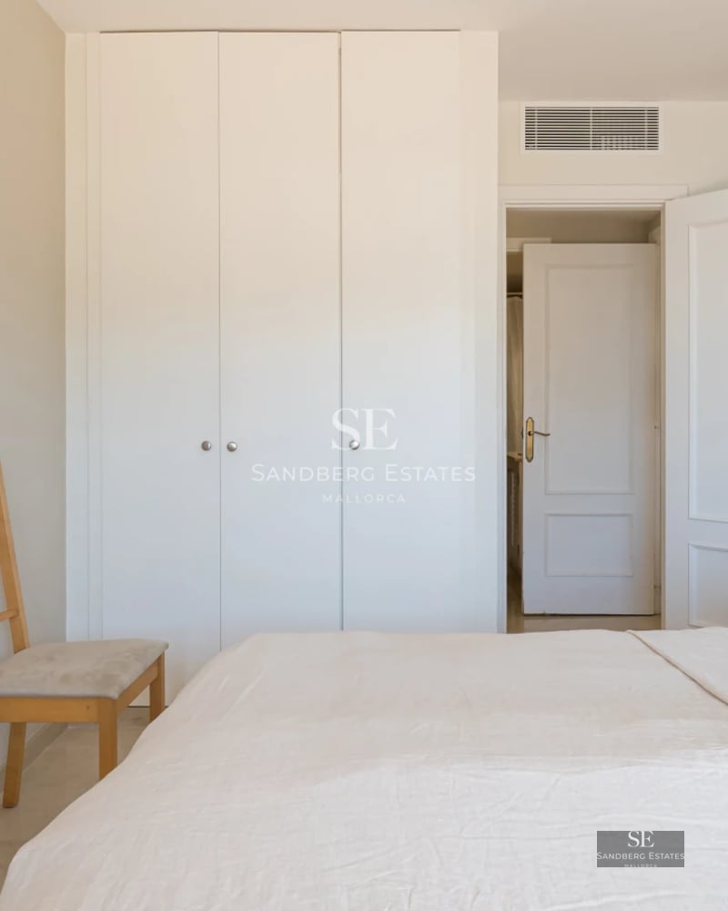 Spacious sea view balcony, modern furniture, glass railing, wooden flooring, and retractable awning. Ambient lighting.