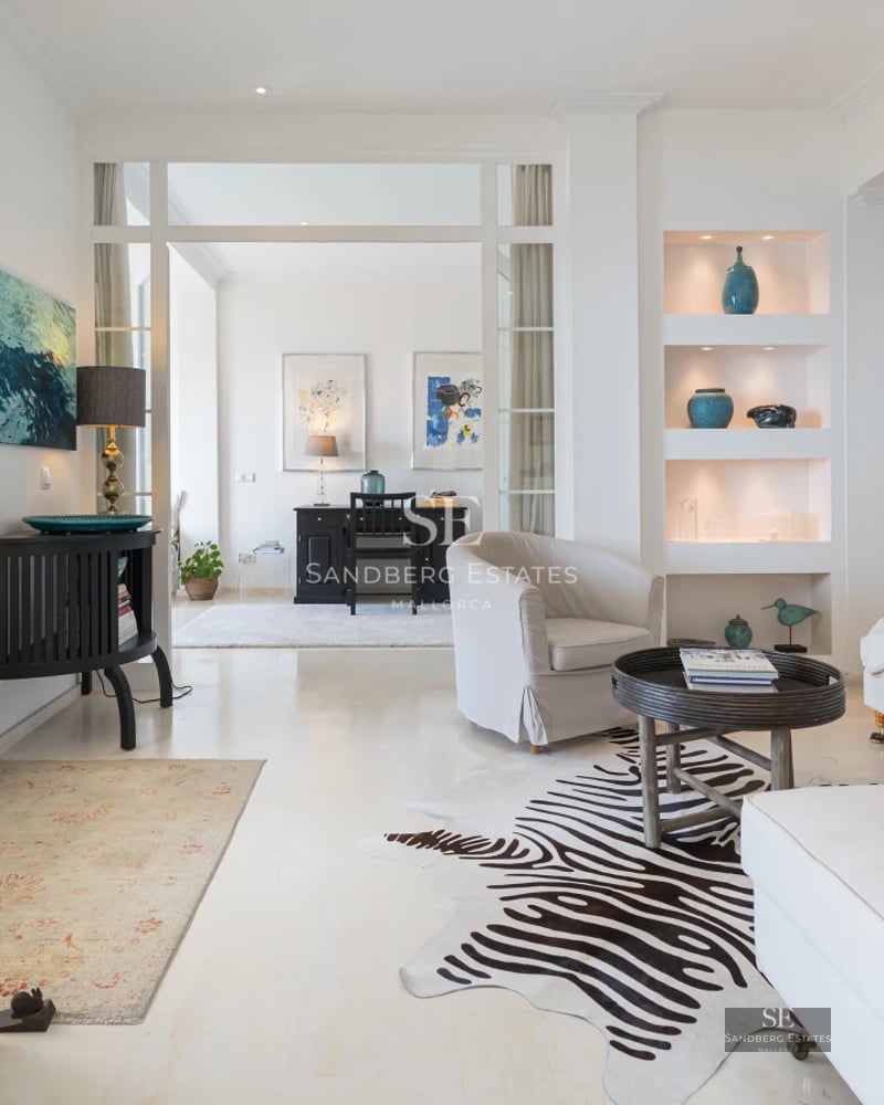 View of a modern villa with reflective pool, lush garden, and large windows offering unobstructed views.