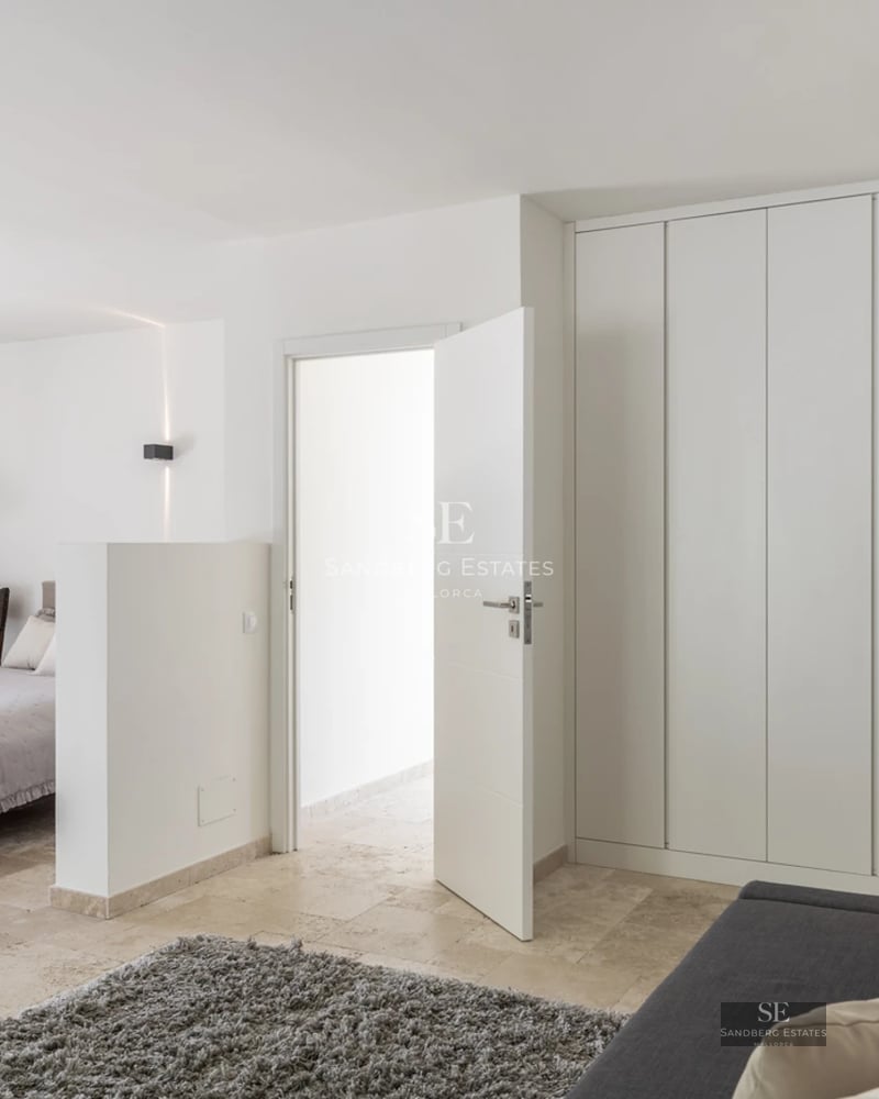 Spacious living room with fireplace, large windows, and access to terrace with pool. Modern and elegant design.