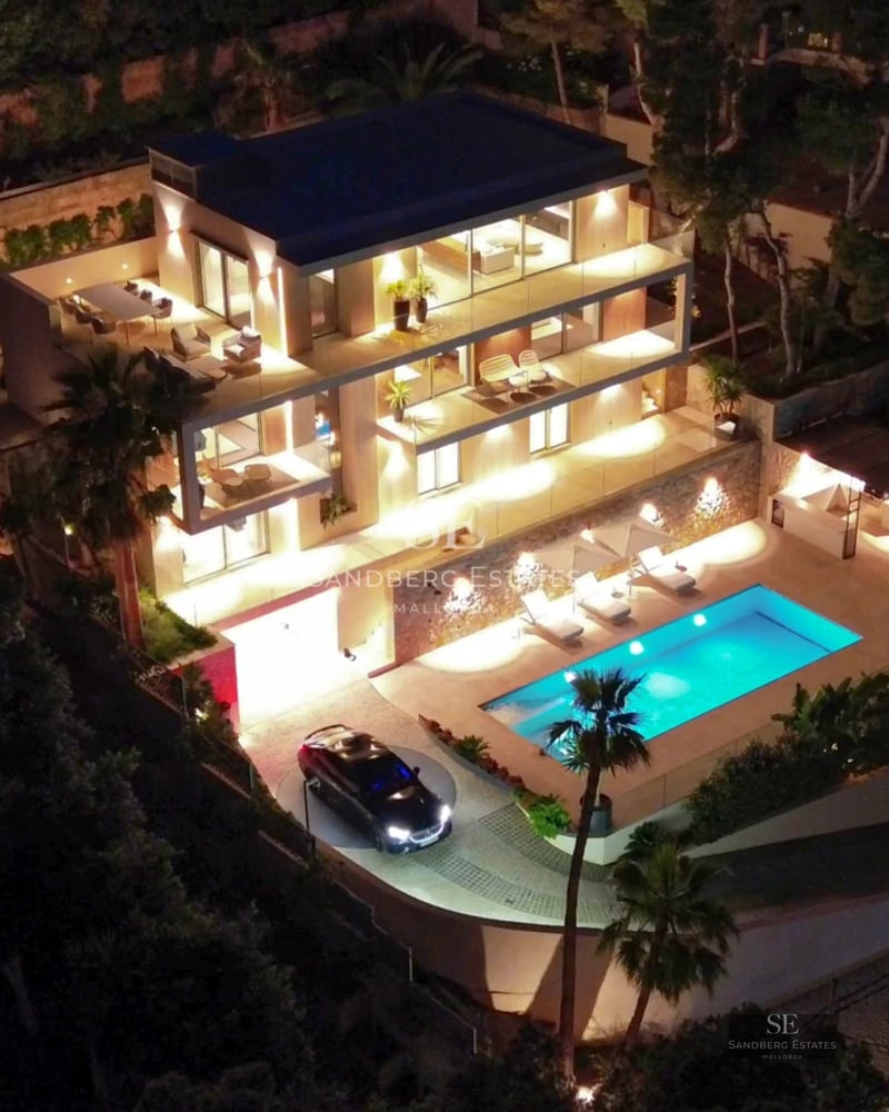 View of luxurious villa with infinity pool, sun loungers, modern architecture, and lush greenery. Minimalist and elegant design.