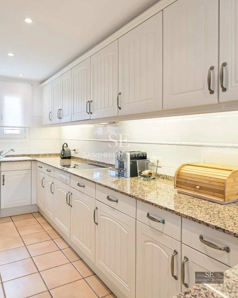 Pool view with sun loungers and lush garden. Modern architecture with large windows. Relaxing and luxurious atmosphere.