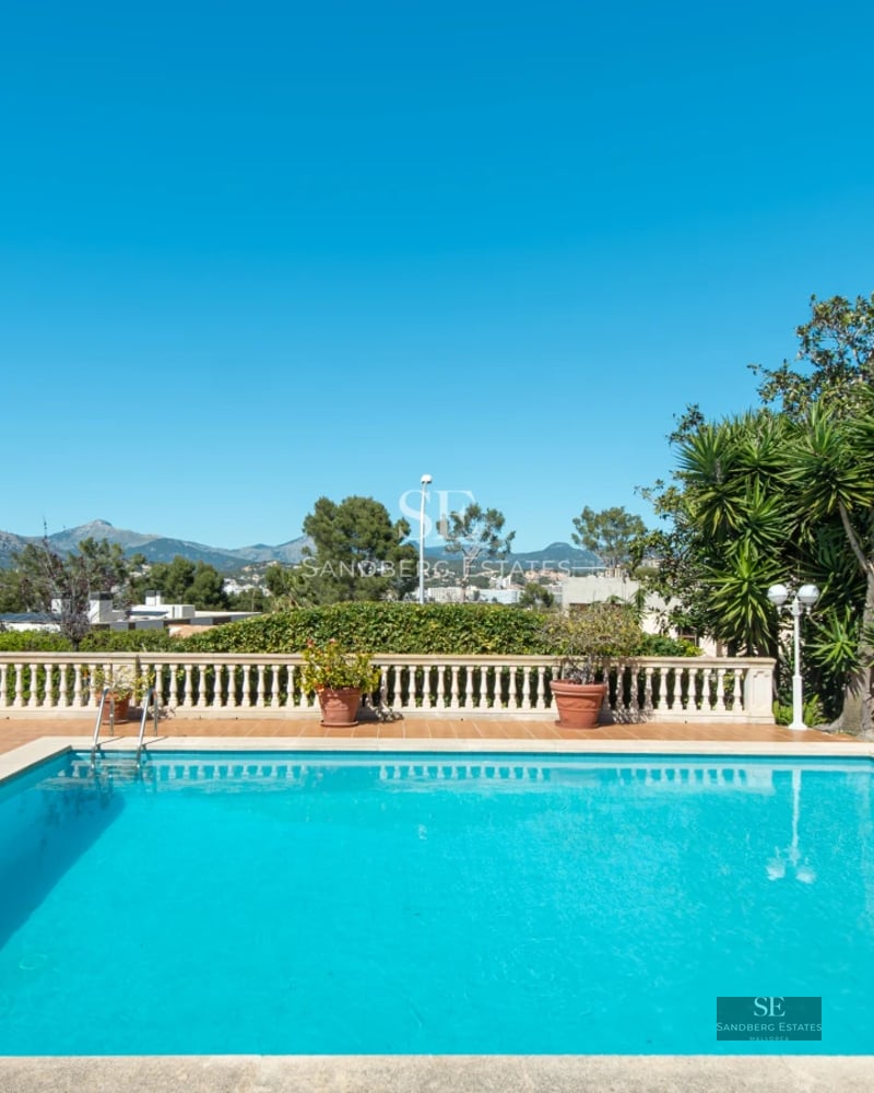 Exterior view of a modern villa with a pool, lush garden, and large terraces. Sleek, minimalist design with abundant natural light.