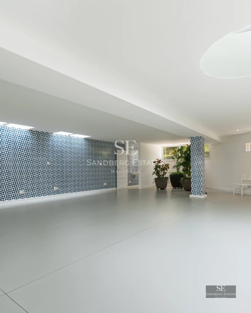 Spacious terrace featuring an infinity pool, sun loungers, and sea views. Modern design with glass railing and wooden flooring.