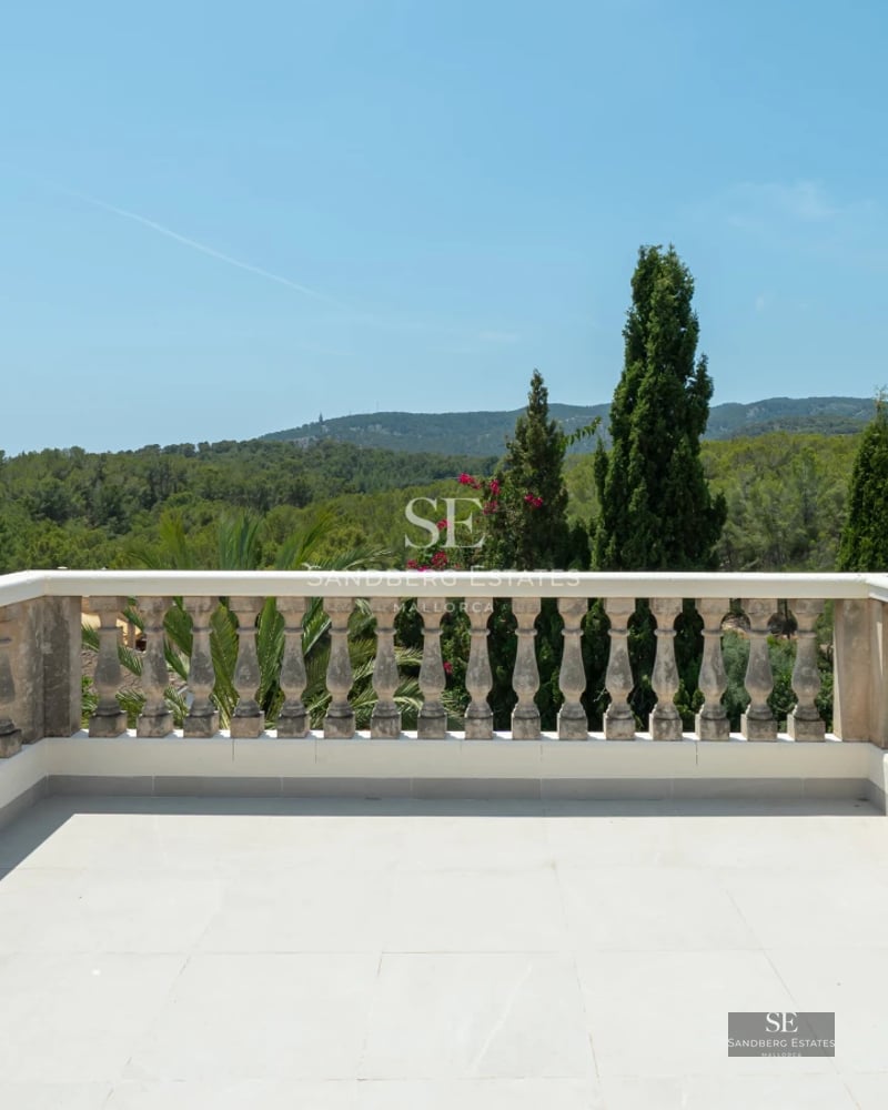 Spacious living room with floor-to-ceiling windows, light wood flooring, modern gray sofas, coffee table, and balcony access with sea view.