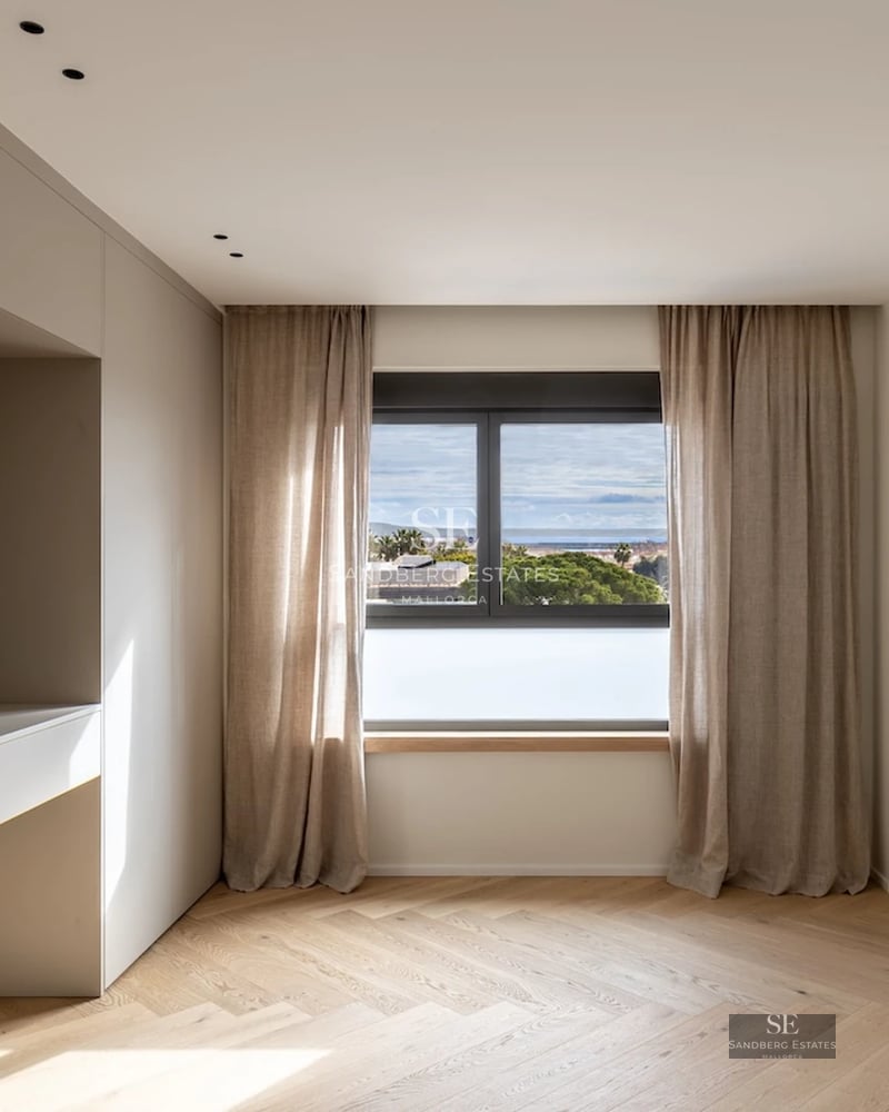 View of a modern villa with a pool, large windows, a terrace, and a lush garden. Clean and elegant architectural design.