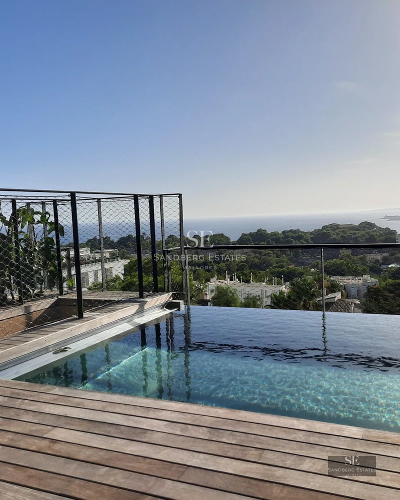 Spacious terrace with infinity pool and panoramic views. Modern architecture with clean lines and large windows.