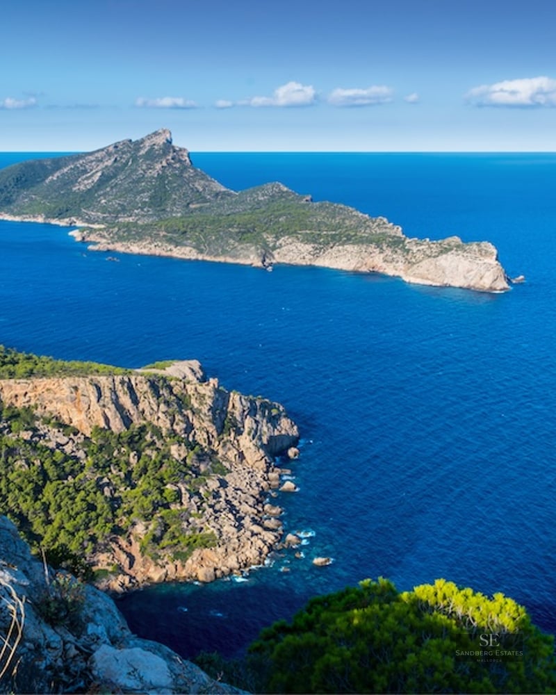 Elevated view of Mallorca's rocky coastline with Dragonera Island set against the deep blue Mediterranean Sea.