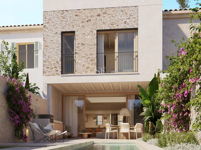 Piscine allongée devant une villa blanche moderne avec façade en pierre naturelle et bougainvilliers.