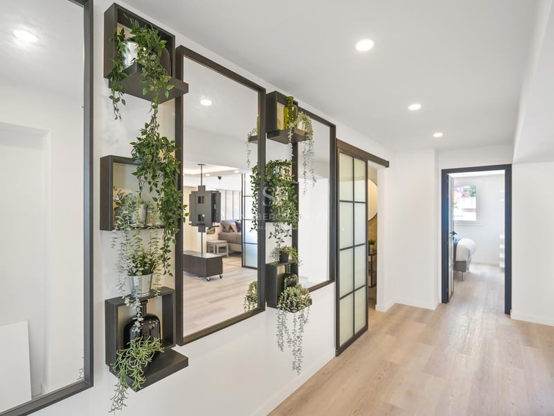 Moderner Flur mit schwarz gerahmten Spiegeln, integrierten Pflanzenregalen und hellem Echtholzboden.