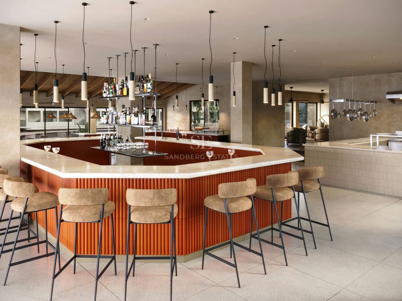 Bar moderne avec comptoir en marbre, base en terre cuite striée et tabourets hauts dans un espace social lumineux.