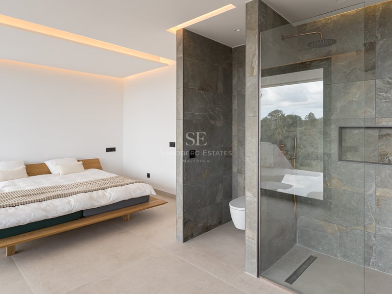 Modernes Schlafzimmer mit schwebendem Holzbett und offenem Bad mit grauen Steinfliesen und Glasdusche.