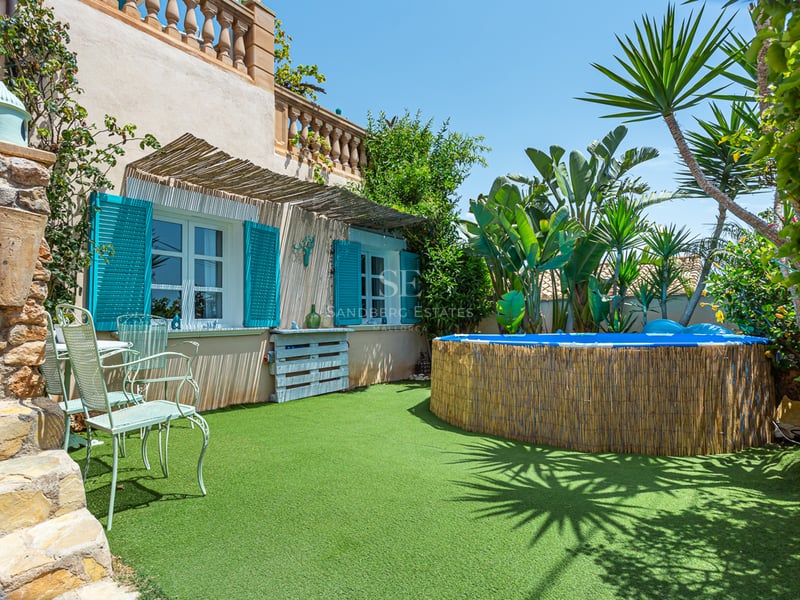 Spacious balcony with glass railing, panoramic sea view, modern outdoor furniture, and retractable awning for shade.