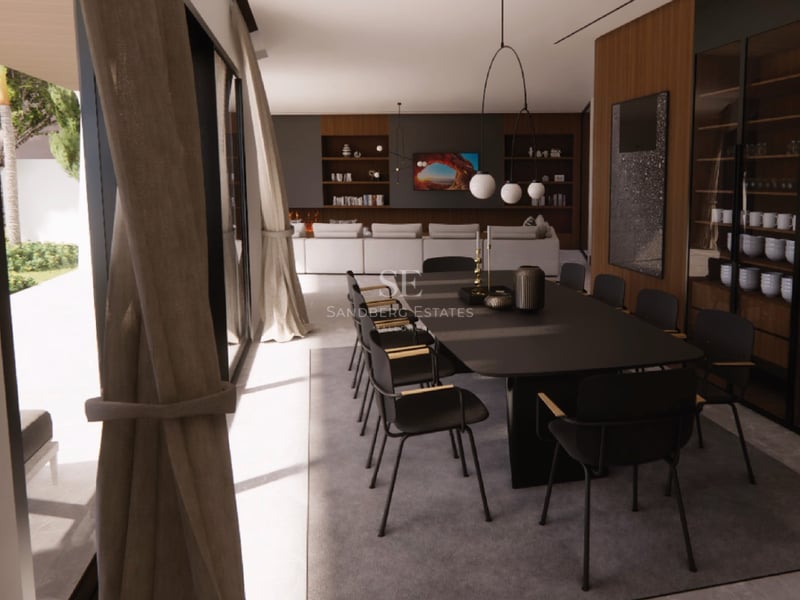 Une table à manger noire élégante entourée de huit chaises dans une pièce lumineuse avec de grandes baies vitrées.