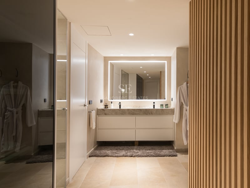 Vanité contemporaine avec plan en marbre, double vasque, miroir LED et boiseries en chêne.