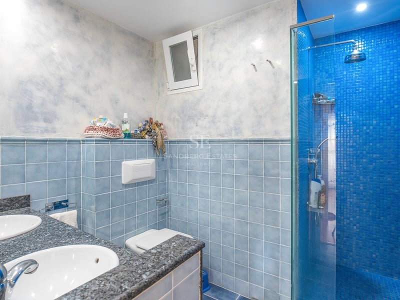 Badezimmer mit blauen Fliesen, Doppelwaschbecken aus Granit und blauer Mosaikdusche.