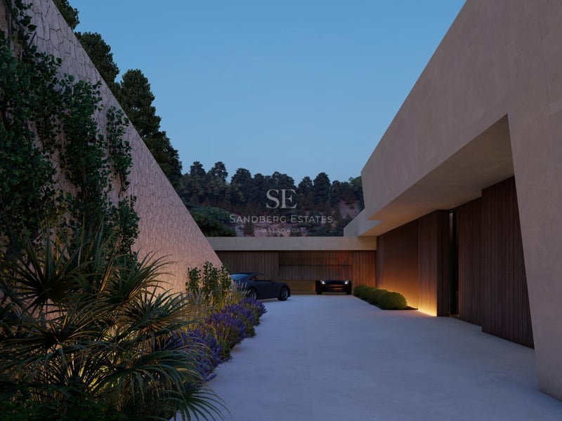 Vue nocturne de l'entrée d'une villa de luxe avec mur en pierre naturelle et éclairage encastré.